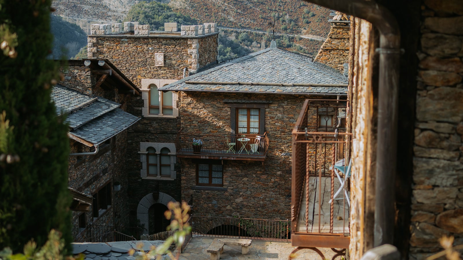 Stone houses cluster on a hillside in a remote mountain village.