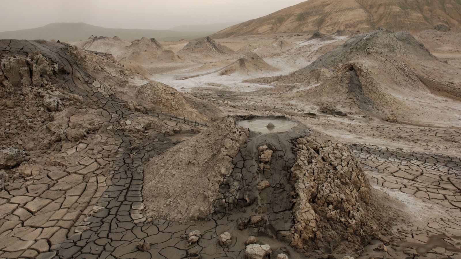 Mud volcano cones and cracked earth in Qobustan, Azerbaijan.