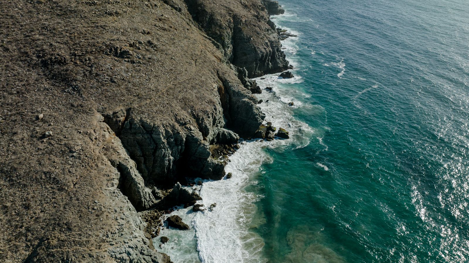 Rocky cliffs meeting the ocean along the Pacific coast of Baja California Sur.