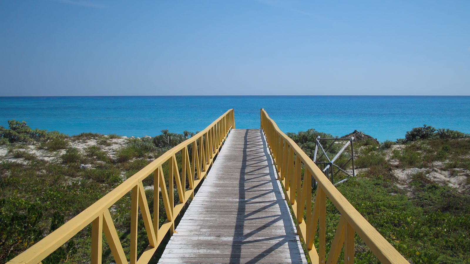 Wooden boardwalk leading to a turquoise Caribbean beach