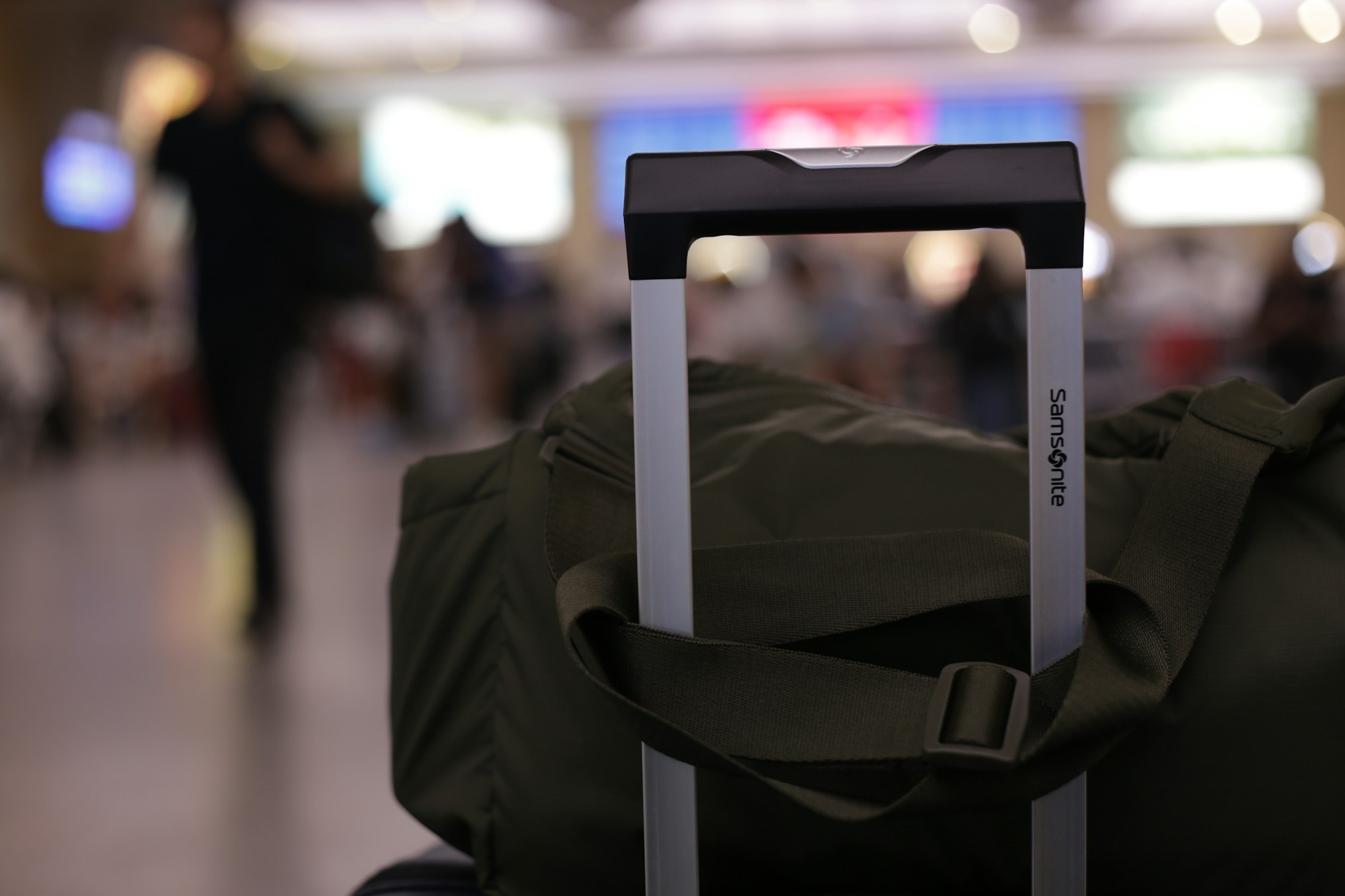 Green duffel bag in an airport terminal