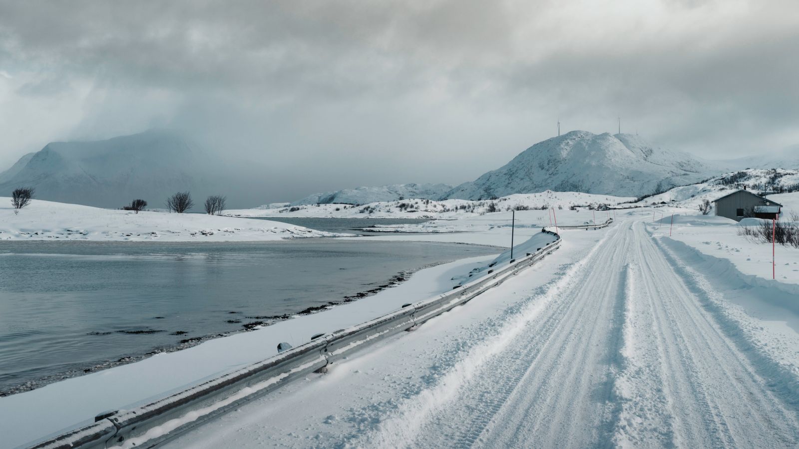 Arctic overland road across a snowy mountain and lake landscape
